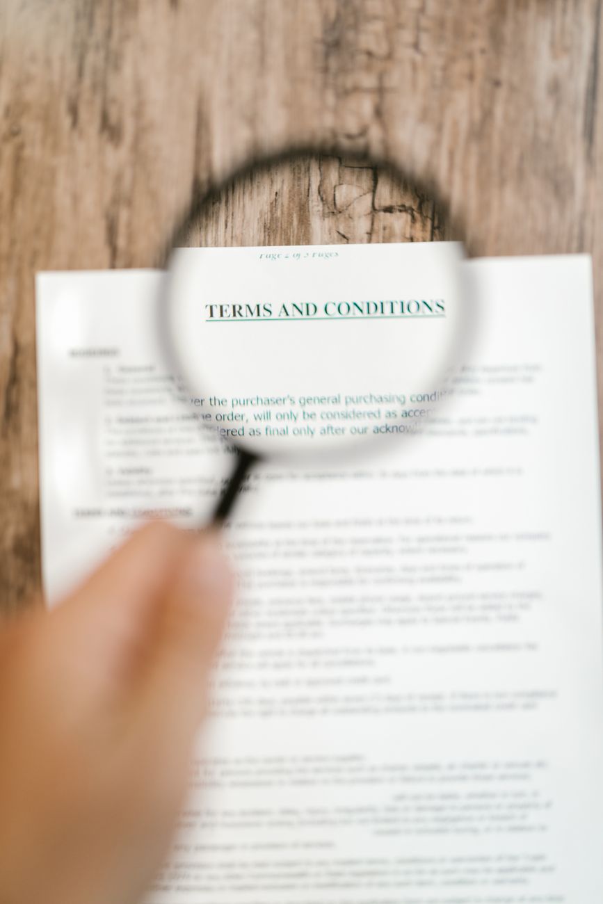 person holding a magnifying glass above a document